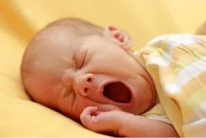 un bMBINO CHE SBADIGLIA fondo giallo