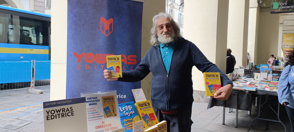 Paolo Domenico Montaldo in uno stand editrice Yowras a Torino con in mano i suoi libri