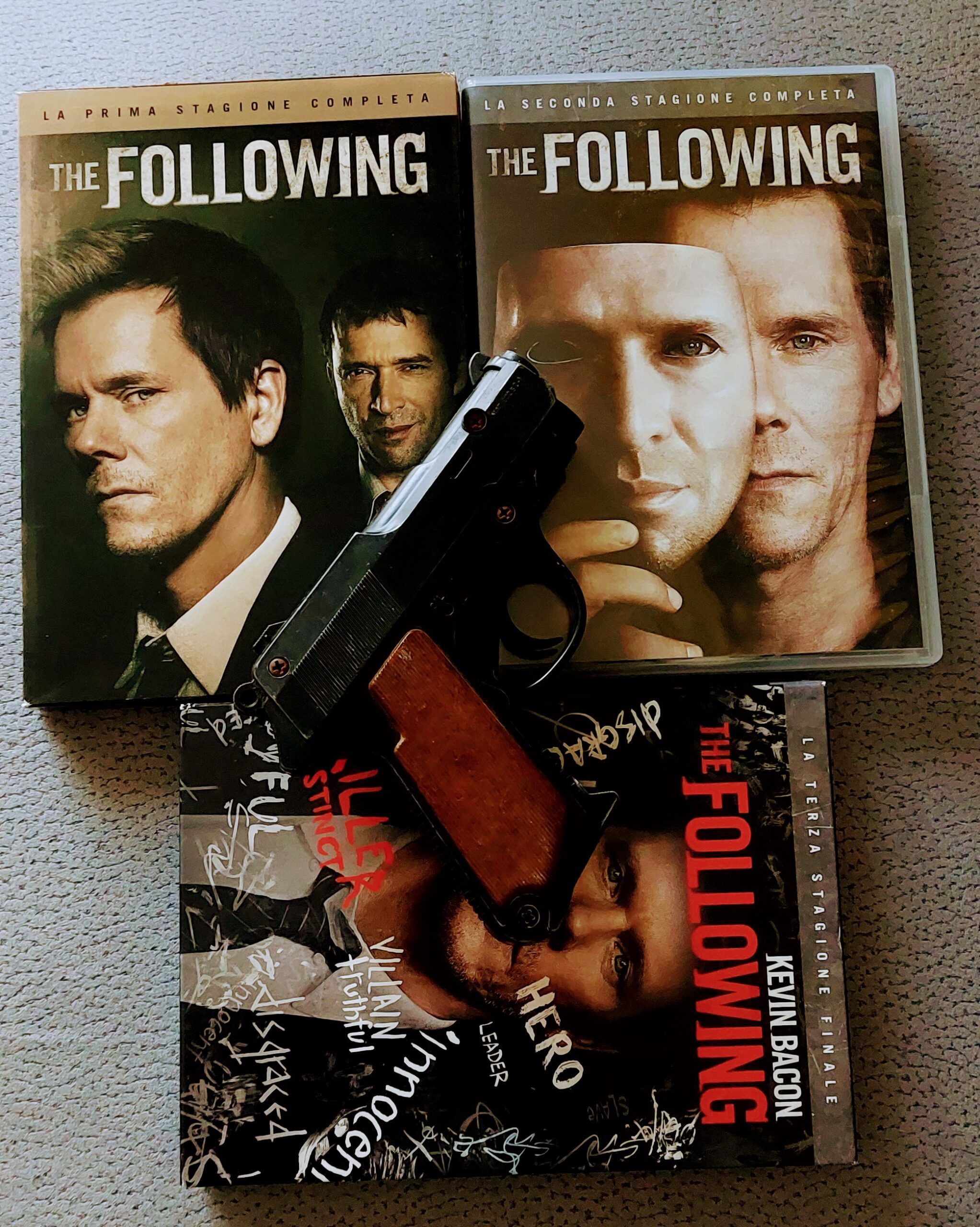 tre stagioni di the following in dvd con una pistola appoggiata sopra