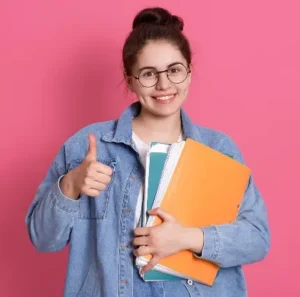 lettura a voce alta studentessa con libri in mano e occhiali con pollice in su