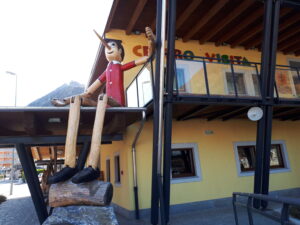 Un Pinocchio di grandi dimensioni seduto su una tettoia a Vernante.