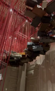 valigia sospese dal soffitto con fili rossi 