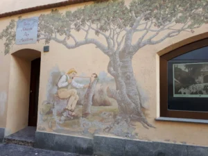 Geppetto inizia a costruire il burattino in uno dei murales di Vernante.