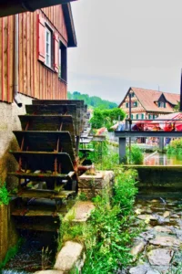 Ruota di un mulino ad acqua con un canale sullo sfondo.
