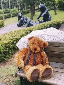 un orsacchiotto di peluche seduto su una panchina 