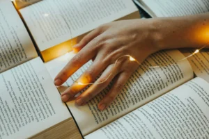 Immagine di pagine di libri con una mano che le sfiora, evocativa dei libri nei film.