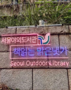 cartello al neon con logo governo Corea con la scritte Seoul outdoor library