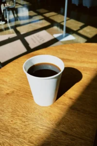 Bicchierino di carta pieno di caffè, immagine evocativa del giallo "Status quo".