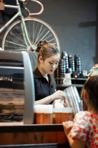 caffetteria e barista asiatica che prepara un ordine