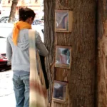 una persona davanti a u tronco con libri buechewald berlin