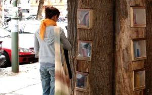una persona davanti a u tronco con libri buechewald berlin