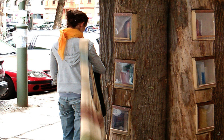 una persona davanti a u tronco con libri buechewald berlin