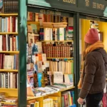 libri esposti in via Po a Toiro in una bancarella dell'usato con una ragazza che li guarda vestita da stagione invernale