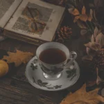 Tazza di te con un libro, piccole zucche e atmosfera autunnale