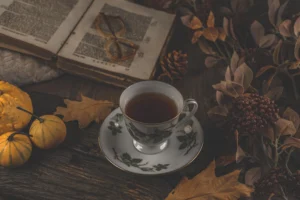 Tazza di te con un libro, piccole zucche e atmosfera autunnale