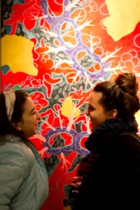 sinestesia due donne che parlano tra colori rossi e neri